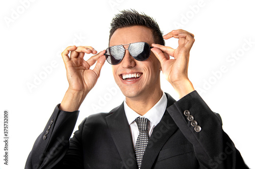 Attractive businessman in suit and tie with huge smile holding sunglasses with grid pattern reflecting in the glasses in white background