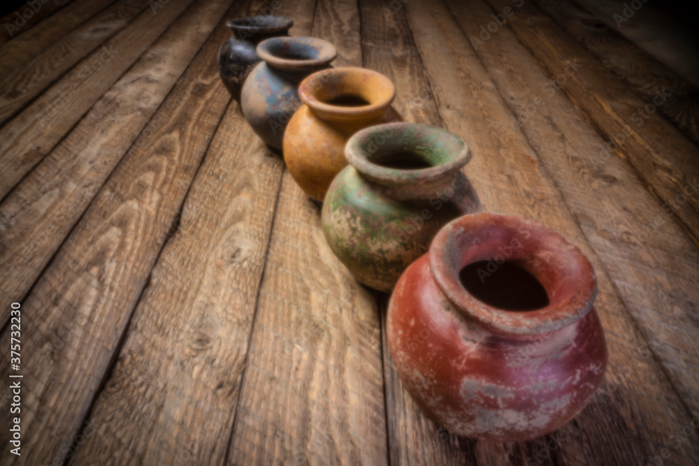 row of small grunge clay pots with rough color finish on a 