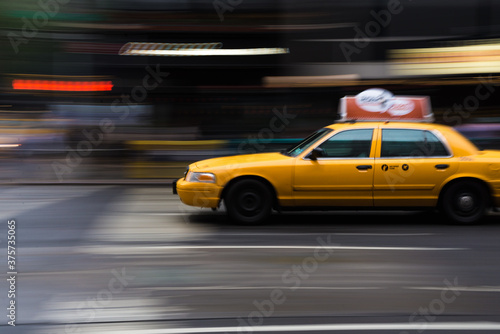 Yellow taxi in motion on a city street