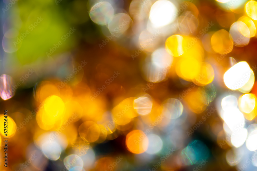Round bokeh, photo of festive lights out of focus, shades of yellow, blue, green, white.