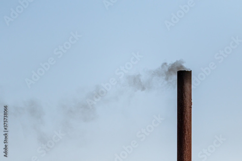 Smoke from the chimney against the blue sky.