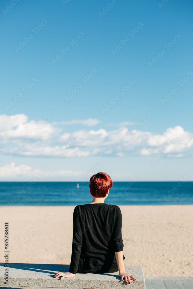 Woman sitting on a bench overlooking the sea Woman sitting on a bench overlooking the sea
