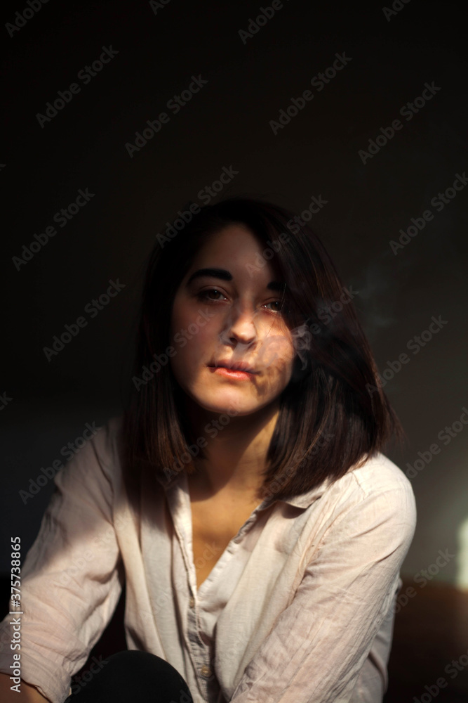 Portrait of a young woman blowing smoke on a light Portrait of a young woman blowing smoke on a light