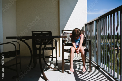 little girl sitting in chair with her head down photo