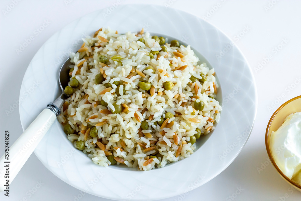 Traditional Turkish rice pilaf with peas and noodles in plate,top view Traditional Turkish rice pilaf with peas and noodles in plate,top view