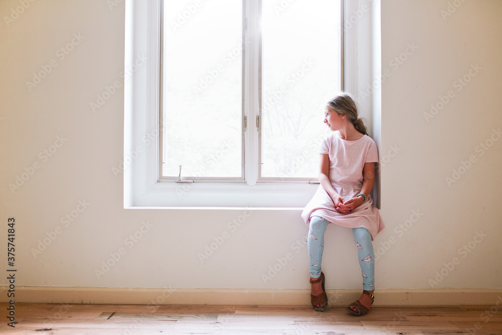 young girl looking out window young girl looking out window