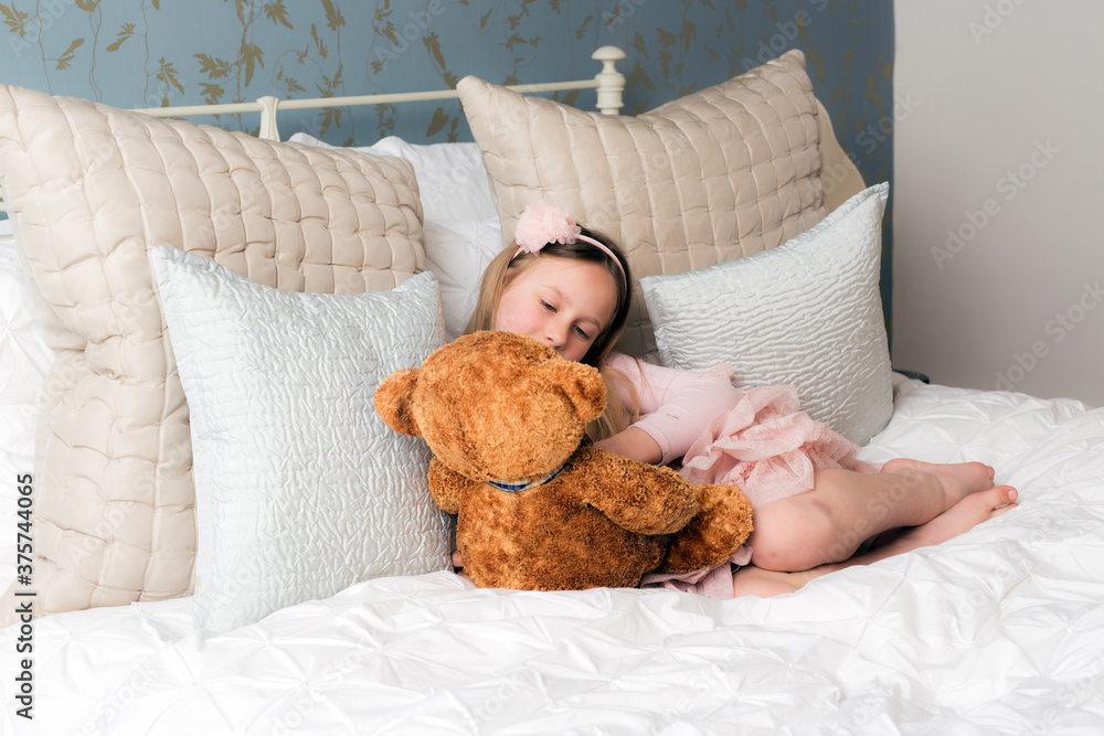 Young girl in a pink dress holding her teddy bear Young girl in a pink dress holding her teddy bear