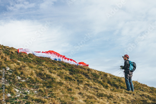 male paraglider on an alpine meadow ready for take off photo