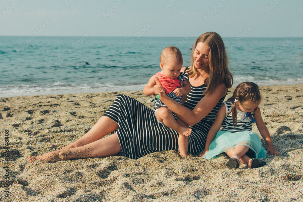 family sittingl on the sand. girl on the beach. Summer vacation by the sea. Travel to hot countries family sittingl on the sand. girl on the beach. Summer vacation by the sea. Travel to hot countries