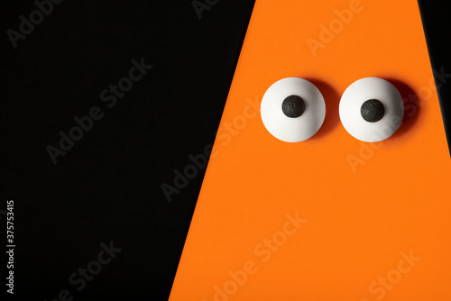 Canvas Print Halloween background, orange ghost with bulging eyes on a black