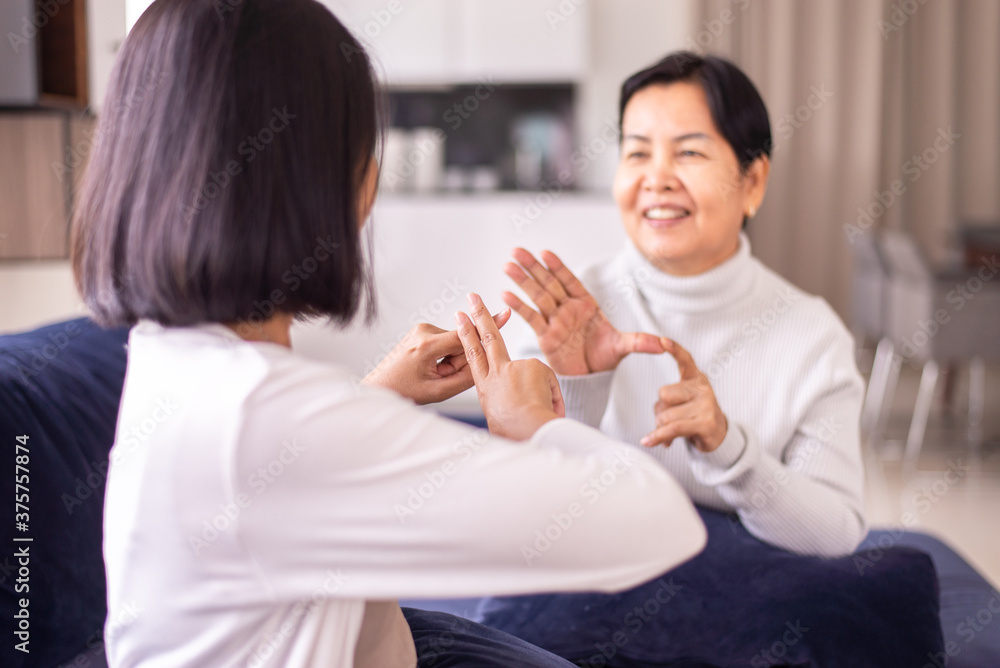 Sign language specialist talking with senior patient deaf hearing and showing hands gesture Sign language specialist talking with senior patient deaf hearing and showing hands gesture