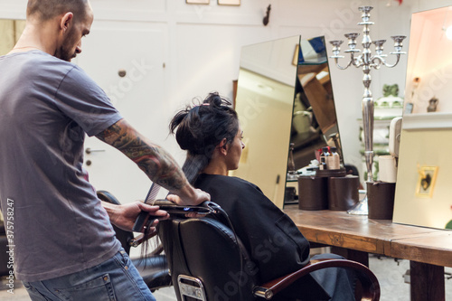 woman is getting her hair straightened with a flat iron photo