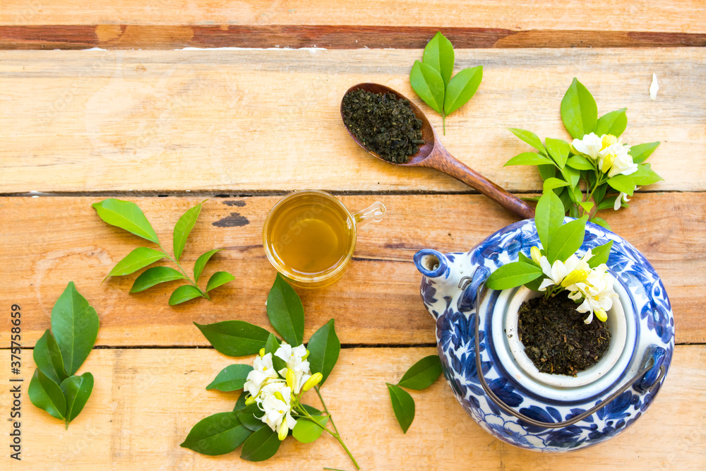 herbal healthy drinks hot green tea with mashed leaf tea in wooden spoon and flower jasmine for relax lifestyle arrangement flat lay style on background wooden herbal healthy drinks hot green tea with mashed leaf tea in wooden spoon and flower jasmine for relax lifestyle arrangement flat lay style on background wooden