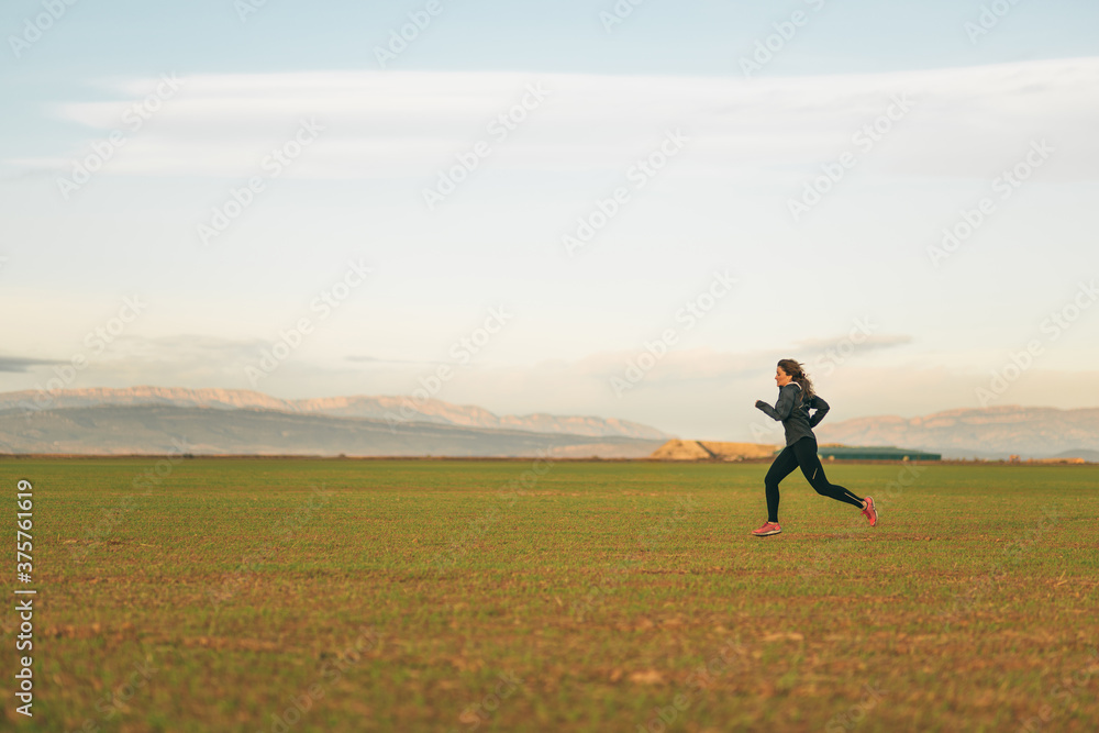 young woman running in the fields at sunset young woman running in the fields at sunset