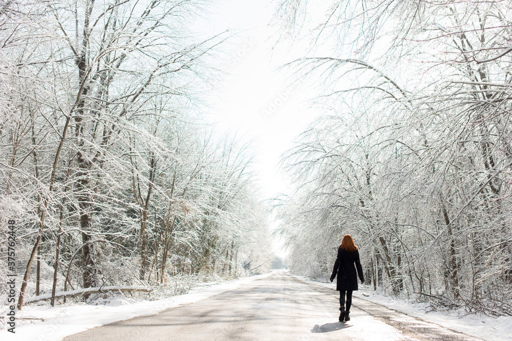 Redhead Woman Walking on Icy Road In Winter With Snow Redhead Woman Walking on Icy Road In Winter With Snow