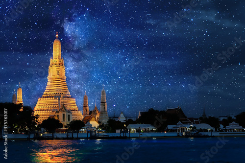 Night time view of Wat Arun Temple in bangkok Thailand  and Milky way galaxy stars and space dust in the universe background. © PhetcharatBiRTH