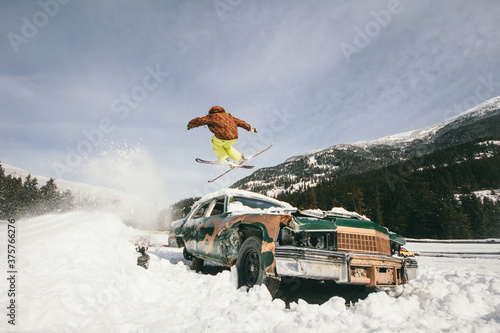 Skier jumping over old vintage abandoned car. Freestyle urban sk photo