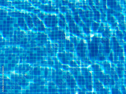 Blue Tiles on the bottom of a swimming pool on a sunny summer day photo