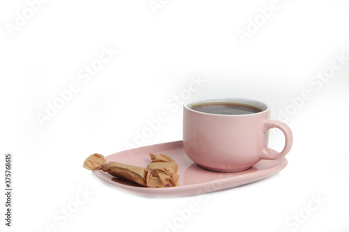 a cup of tea on a saucer and stickjaws isolated on white background photo