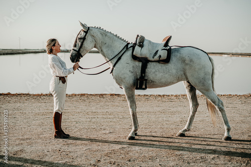 Chica con caballo yegua tordo torda playa natural camino trote doma playa salina camino naturaleza sanlucar rocio virgen campo ecuestre