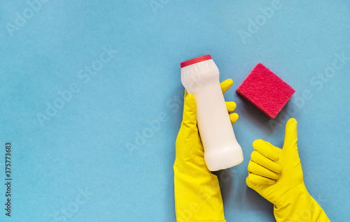 Woman's hand cleaning on a blue background.Cleaning or housekeeping concept background. Copy space. Flat lay, Top view.