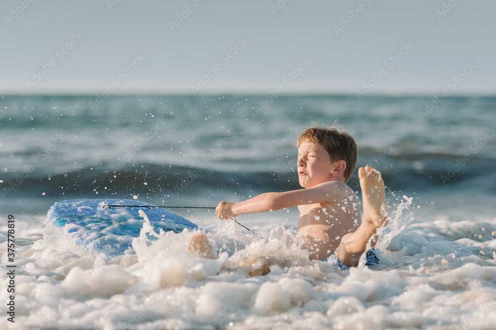 Boy falling off surf board into waves Boy falling off surf board into waves