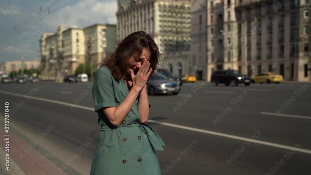 Smiling crazy adult woman strolls along a busy highway Smiling crazy adult woman strolls along a busy highway