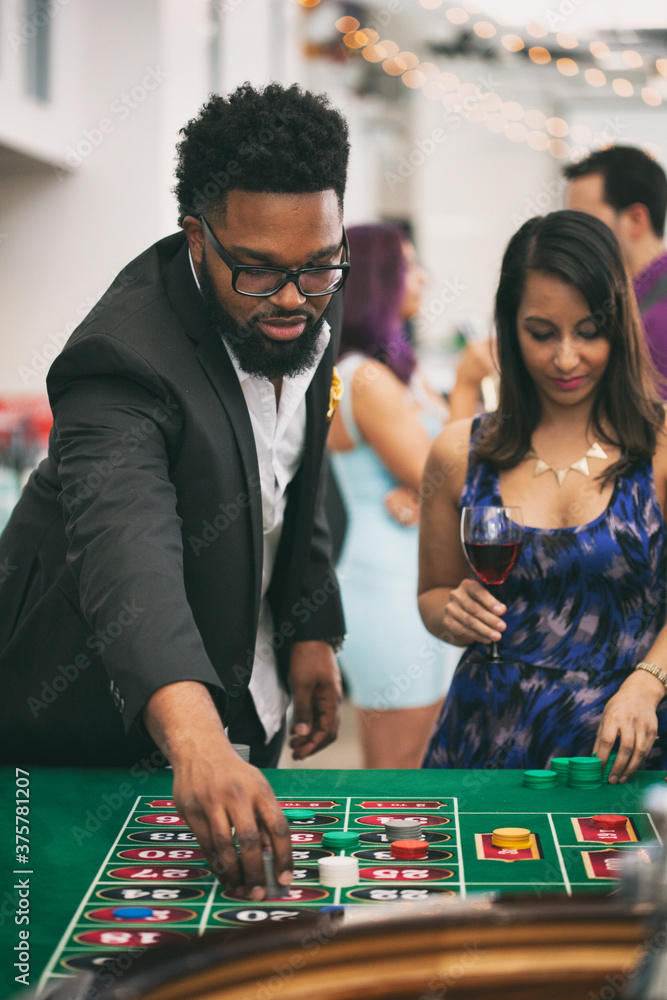 Casino: Man Putting Down Bets For Game Of Roulette Casino: Man Putting Down Bets For Game Of Roulette