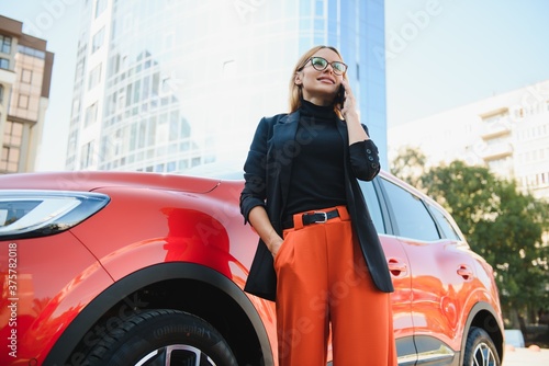 Professional female manager standing near car at office building © Serhii