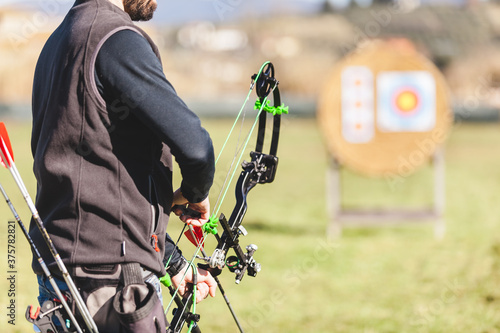 Professional Male Archer Loading an Arrow on the Bow photo