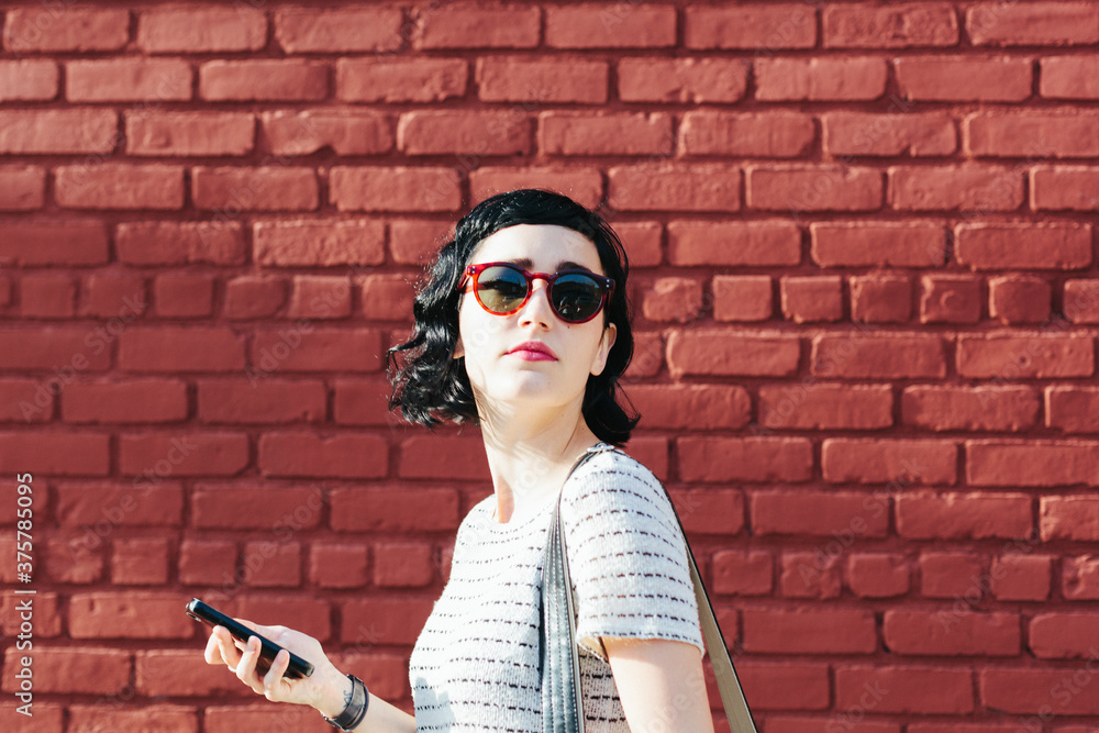 Brunette holding a cell phone outdoors Brunette holding a cell phone outdoors