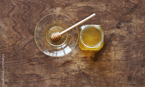 The idea of natural products. On a wooden natural ancient background honey and a spoon with honey.