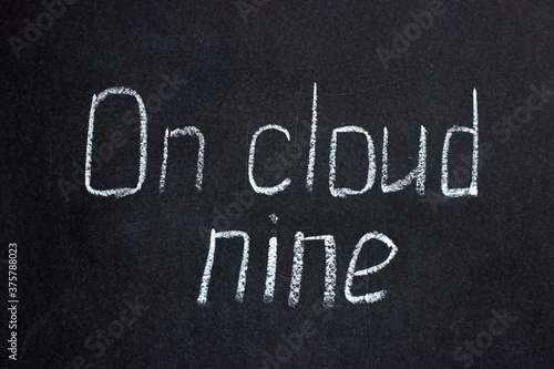  Chalk writing on a dark board On cloud nine. Common phrase