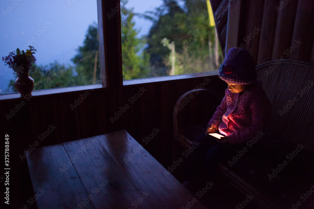 Child with mobile phone at dusk Child with mobile phone at dusk