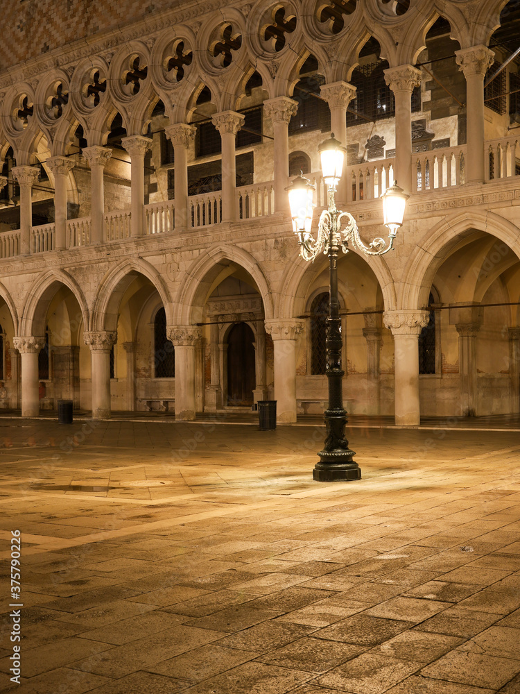 St. Mark's square in Venice, Italy at night. A street lamp illuminating the beautiful stone floor in front of the Doge's Palace.