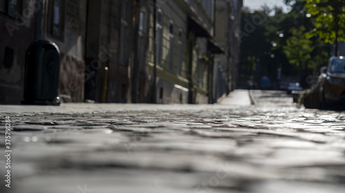 Old city paving stones with depressions between the stones, close-up, selective focus, dark tone.