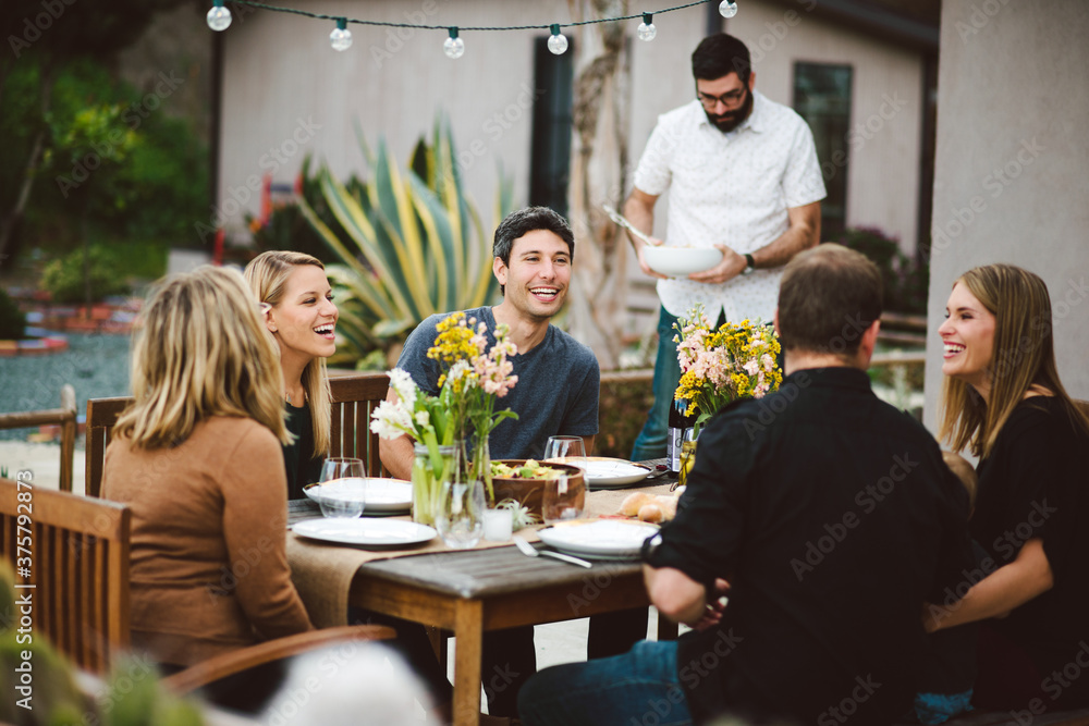 Friends having a backyard dinner party in the summer. Friends having a backyard dinner party in the summer.