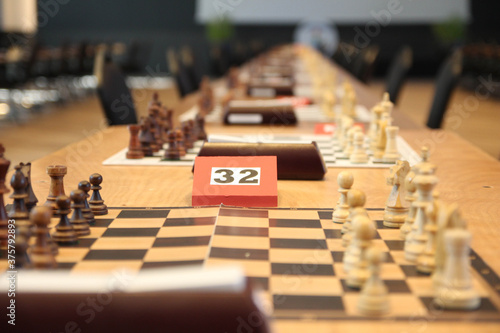 Chess boards on tables during Chess Championship. The tournament. Chess board with white, black pieces and clock on desk. Plan leading strategy of successful business competition leader concept.