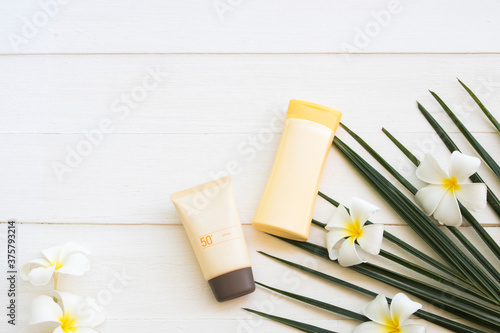 natural cosmetics sunscreen spf50 health care for skin face with body lotion of lifestyle woman relax summer and flower frangipani ,coconut leaf arrangement flat lay style on background white 