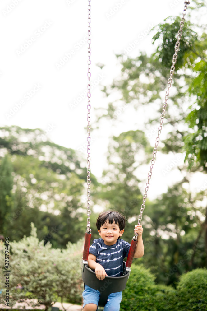 Little boy sitting on a swing in the park Little boy sitting on a swing in the park