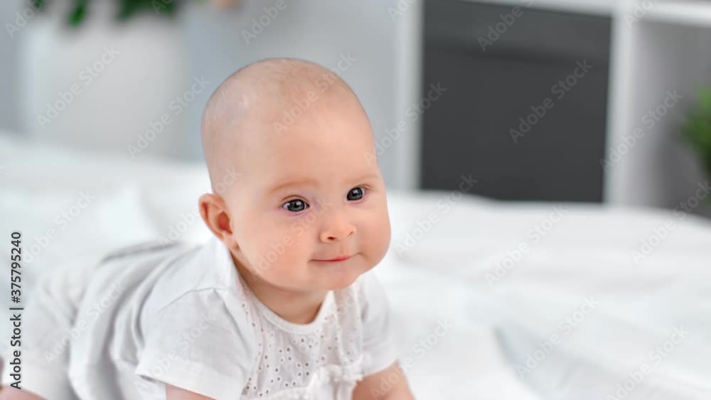 Cheerful cute little boy or girl crawl on comfortable bed. Shot on RED Raven 4k Cinema Camera Cheerful cute little boy or girl crawl on comfortable bed. Shot on RED Raven 4k Cinema Camera
