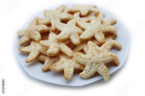 Salty cheese cookies in shape of a starfish on a plate  isolated on white background
