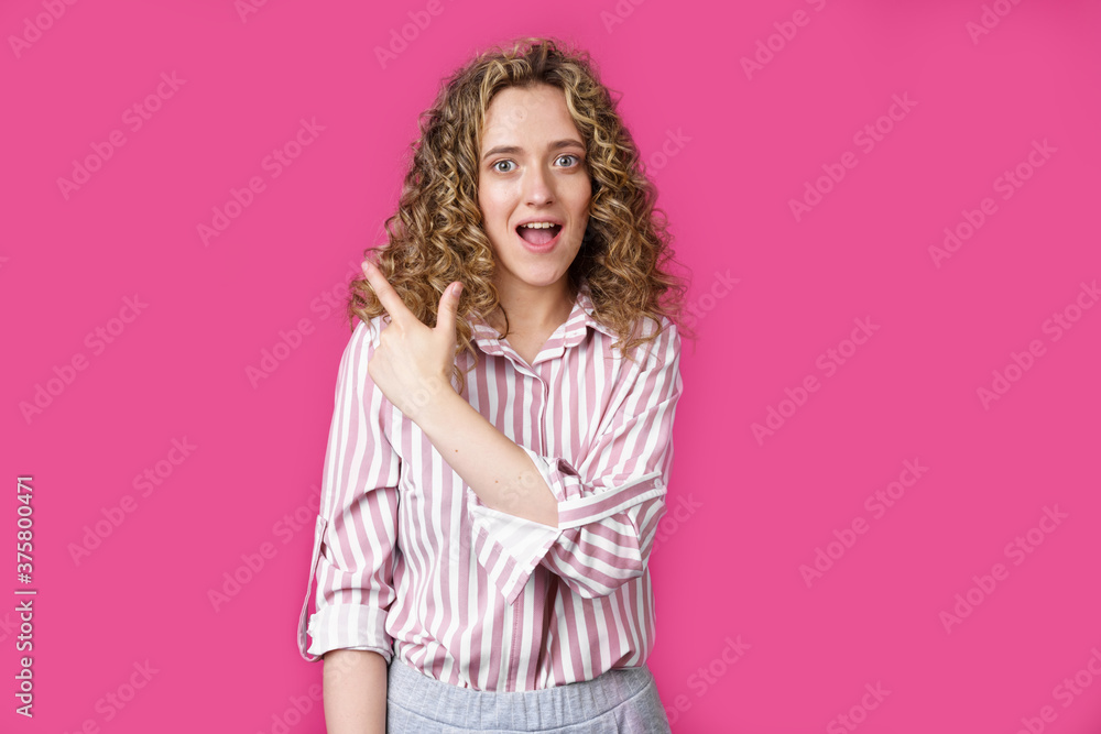 Young beautiful woman shows her finger to the left. Young beautiful woman shows her finger to the left.