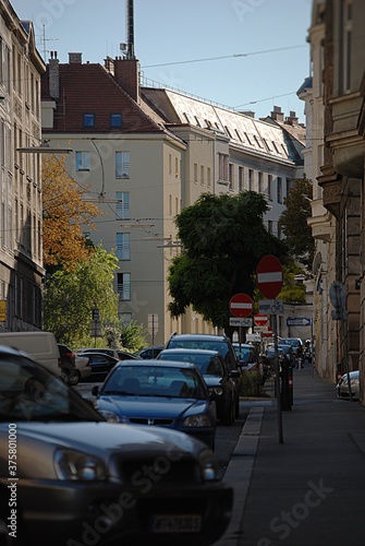 Fototapeta Naklejka Na Ścianę i Meble -  Ein Stadtbild mit enger Gasse, Häusern, Stromleitungen und einer Handyantenne am Dach.