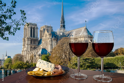 Wallpaper Mural Two glasses of red wine with assortment of cheese and meat against Notre Dame de Paris or Notre-Dame Cathedral in Paris, France. Romantic celebration. Torontodigital.ca