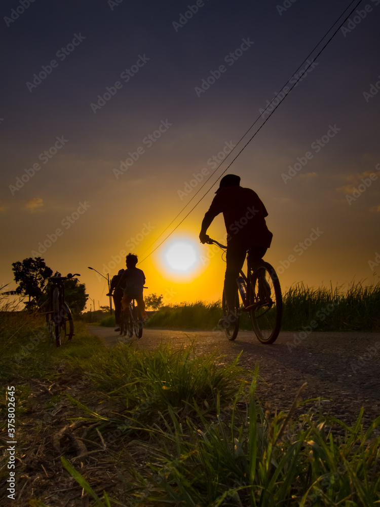 silhouette of a man riding a bike