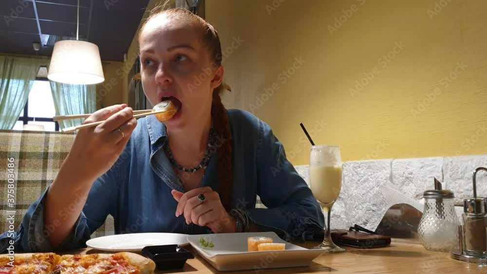 woman eating Japanese rolls in a restaurant with chopsticks. lunch break, healthy food woman eating Japanese rolls in a restaurant with chopsticks. lunch break, healthy food