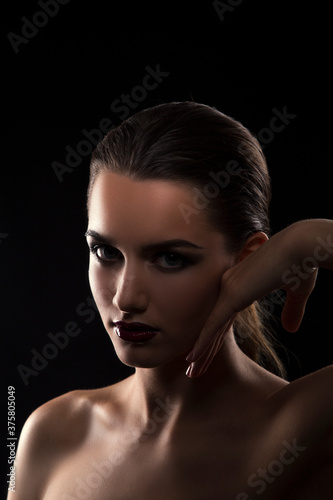 Beauty woman silhouette portrait, clean skin, hand near face. Dark background