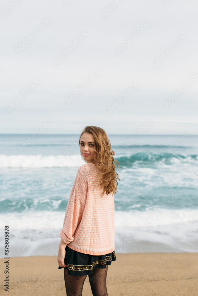 Smiling woman standing in front of the sea Smiling woman standing in front of the sea