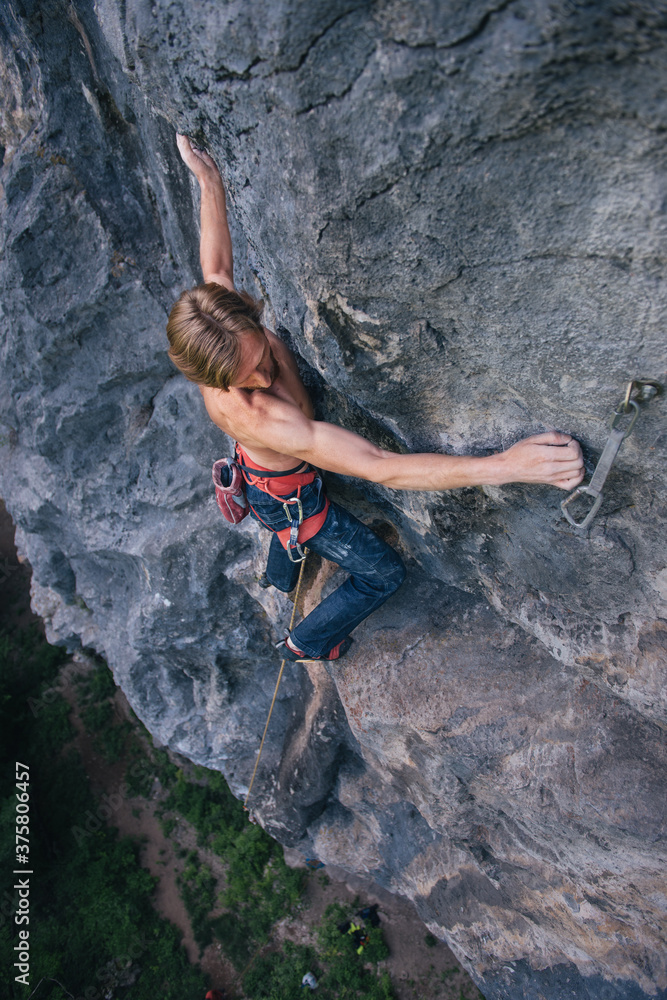 Rock climber keeping his balance high on the rock Rock climber keeping his balance high on the rock